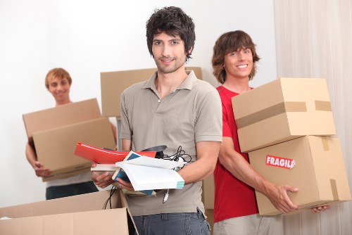 Moving crew carrying items through a Balham flat entrance